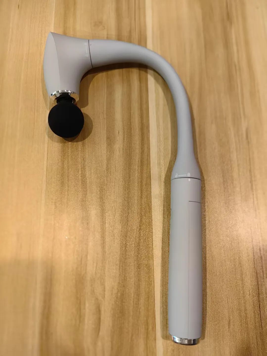 Person struggling to reach back with short massage gun